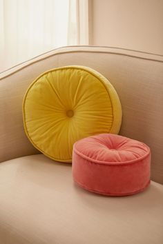 two round cushions sitting on top of a couch