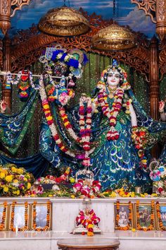 an idol is displayed in the middle of a stage with flowers and decorations around it