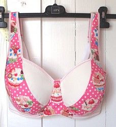 a pink bra with hello kitty on it is hanging from a hook in front of a white door