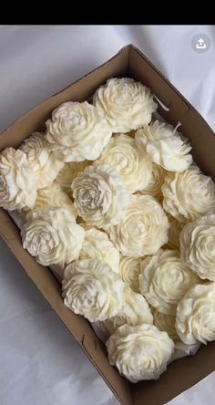 a box filled with white roses on top of a table