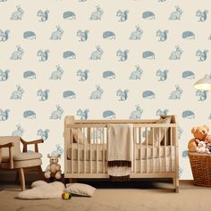 a baby's room with a crib, rocking chair and stuffed animals on the wall