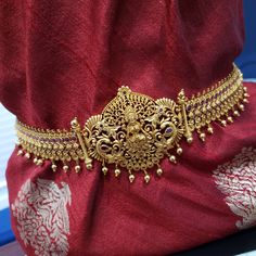 This vaddanam has high-quality Pearls, American Diamonds, Semi-precious Ruby, and emeralds. Ideal for weddings and special occasions. Traditional wedding accessories for silk sarees and most preferred jewelry for grand family occasions and parties. *Total length of the hip belt (end -to end) is 41 Inches, but suitable for a hip size less than 40 Inches. *Design on the Front portion is 13 inches. The rest is made up of a one-inch wide flat belt. The height of the center portion with the design is Temple Jewelry Bridal Belt With Tilla For Wedding, Gold Temple Jewelry Style Bridal Belt For Wedding, Traditional Gold Bridal Belt For Wedding, Festive Temple Jewelry Bridal Belt For Wedding, Ceremonial Temple Jewelry Bridal Belt With Tilla, Gold Temple Jewelry Traditional Wear For Ceremonies, Bollywood Bridal Belt For Diwali Ceremonial, Traditional Gold Bridal Belt For Festivals, Gold Bridal Belt For Festive Occasion, Temple Jewelry Style