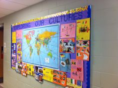 a bulletin board on the wall in a school hallway with pictures and magnets attached to it