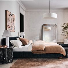 a bedroom with a bed, mirror and lamp in it