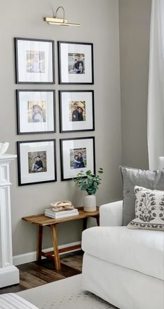 a living room with white furniture and pictures on the wall above it's fireplace