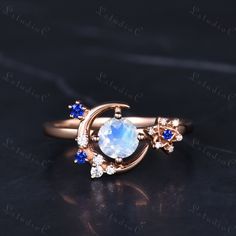 the moon and stars ring is shown with blue sapphire stones on it's side