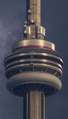 the top of a tall building with a clock on it's side and a sky background