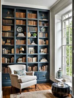 a living room filled with lots of bookshelves and furniture next to a window