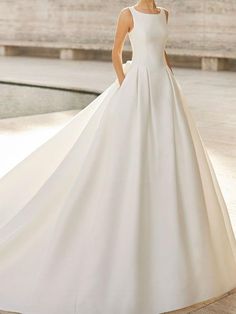 a woman in a white wedding dress posing for the camera with her hands on her hips