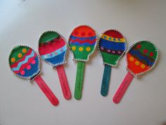 five colorful spoons are sitting on a table