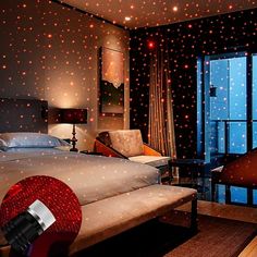 a bedroom with stars on the walls and ceiling, along with a large bed in front of a window