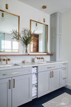 a bathroom with two sinks, mirrors and towels on the counter top next to each other