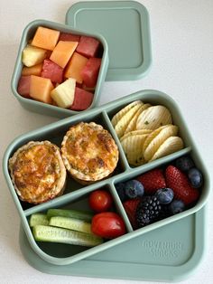 two plastic containers filled with fruit and veggies next to each other on a table