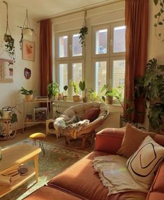 a living room filled with lots of furniture and plants on the windows sills