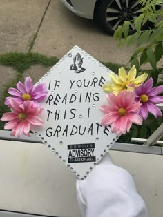 a graduation cap with flowers attached to it that says if your reading this i graduate