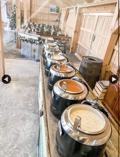 a row of crockpots sitting on top of a counter in a barn