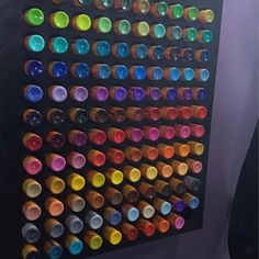 an art piece with many different colored bottles on it