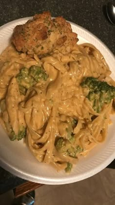 a white plate topped with pasta and broccoli