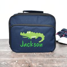 A lovely Personalised Crocodile Lunch Bag the perfect size for you child at school to fit all his much needed fuel for school. This Crocodile School Lunch Bag is blue and features your child's name so that it's sure not to get lost and a Crocodile a much loved animal. This Kids Animal Cooler Bag is white inside and is waterproof. Use this Boys School Lunch Bag for any age of child for school trips, nursery school, picnics and more. Suitable for Children Student a Back To School item. Dimensions- Green School Satchel, School Satchel Bag With Animal Design, School Satchel With Animal Design, School Bags With Animal Design For Back To School, Green Lunch Bag For School, School Trips, Unicorn Cushion, School Lunch Bag, Kids Lunch Bags