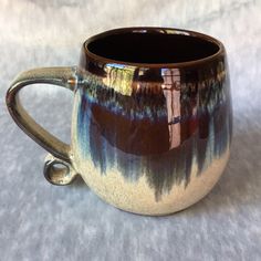 a brown and blue mug sitting on top of a white table