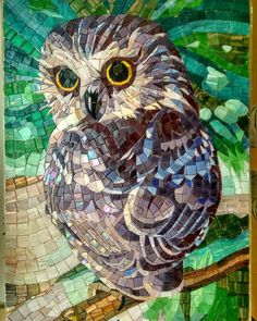 an owl sitting on top of a tree branch covered in lots of small mosaic tiles