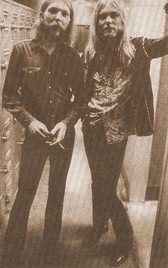 two men standing next to each other in front of lockers