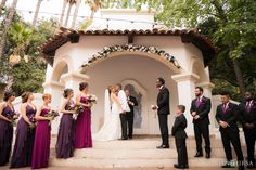 a group of people that are standing in front of a gazebo with flowers on it