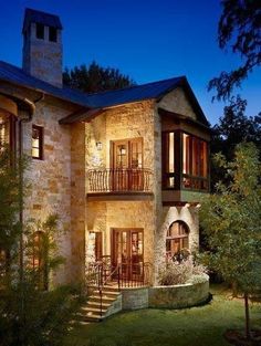 a large stone house lit up at night