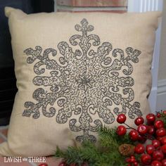 a decorative pillow is sitting on the floor next to some christmas decorations and greenery