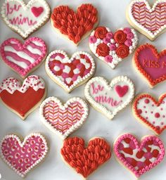 many decorated cookies are arranged in the shape of hearts