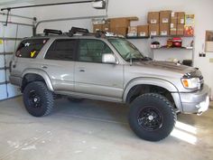 a silver truck parked in a garage next to shelves