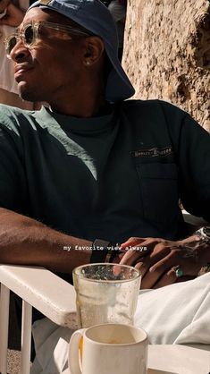 a man sitting in a chair next to a cup