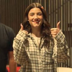 a young woman giving the thumbs up sign