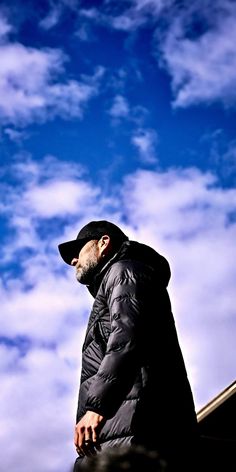 a man standing on top of a roof under a blue sky