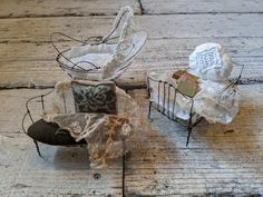 two small metal chairs sitting next to each other on a wooden floor and covered in lace