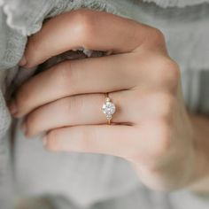 a woman's hand with a diamond ring on it