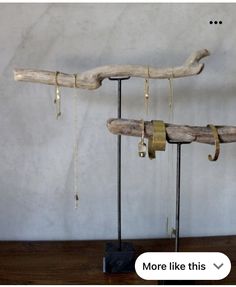 two pieces of driftwood are on display with chains hanging from it's ends