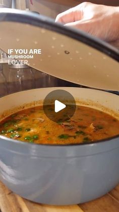 a person is pouring some soup into a pot