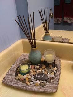 a bathroom sink with rocks and candles on it