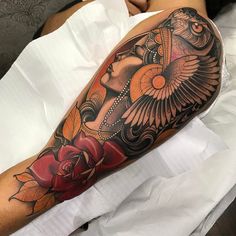 a woman's arm with an owl and rose tattoo design on the left forearm