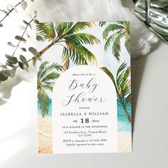 a baby shower is shown with palm trees and the ocean in the background, on a white surface