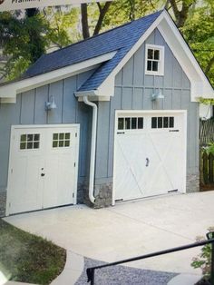 a gray garage with two white doors and windows