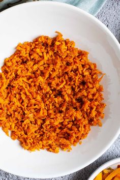 a white bowl filled with cooked carrots on top of a table