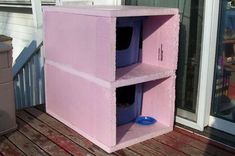 a pink shelf sitting on top of a wooden deck next to a door and window