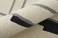 a close up view of a rug with black and white stripes on the bottom half