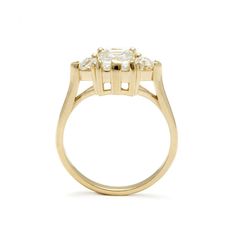 a yellow gold ring with three stones in the center and two diamonds on each side