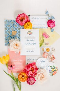 the wedding stationery is laid out on top of each other with flowers and stamps