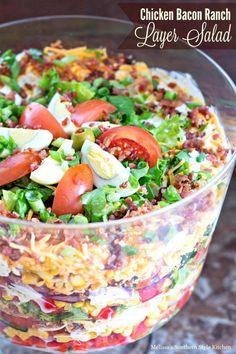 chicken bacon ranch layered salad in a glass bowl on a table with text overlay