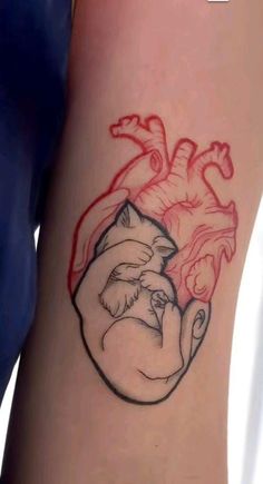 a tattoo on the leg of a woman with a heart and two cats in it