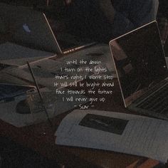 two laptops sitting on top of a desk with a quote written in front of them